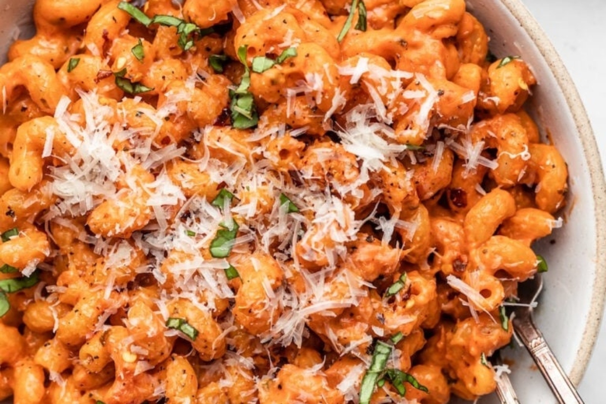 A bowl of pasta with sauce and parmesan cheese offering a delicious option for picky eaters.