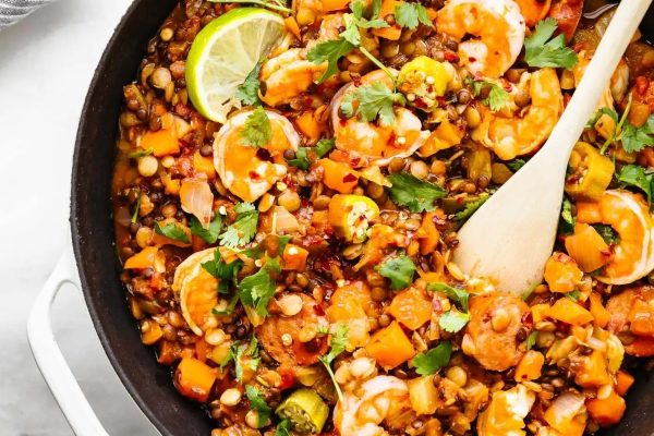 A skillet filled with shrimp and vegetables.