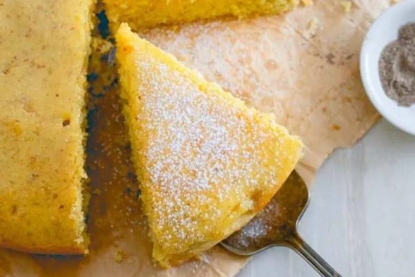A slice of cake with powdered sugar on top.