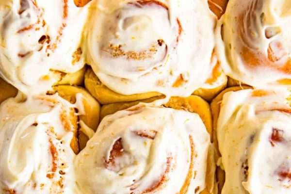 A plate of cinnamon rolls with a generous drizzle of icing.