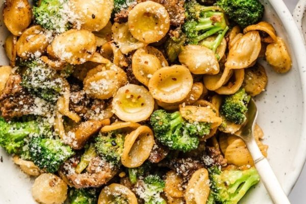 A bowl of pasta with broccoli and parmesan.