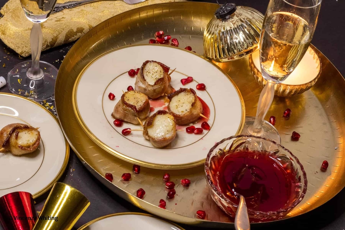 A table with plates, glasses, and pomegranate on it, perfect for creating delicious pomegranate recipes.
