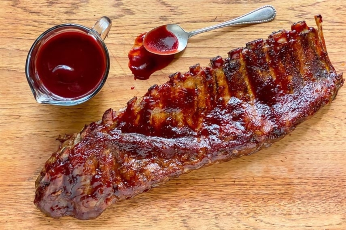 Recipes: Ribs with sauce and a spoon on a wooden table.