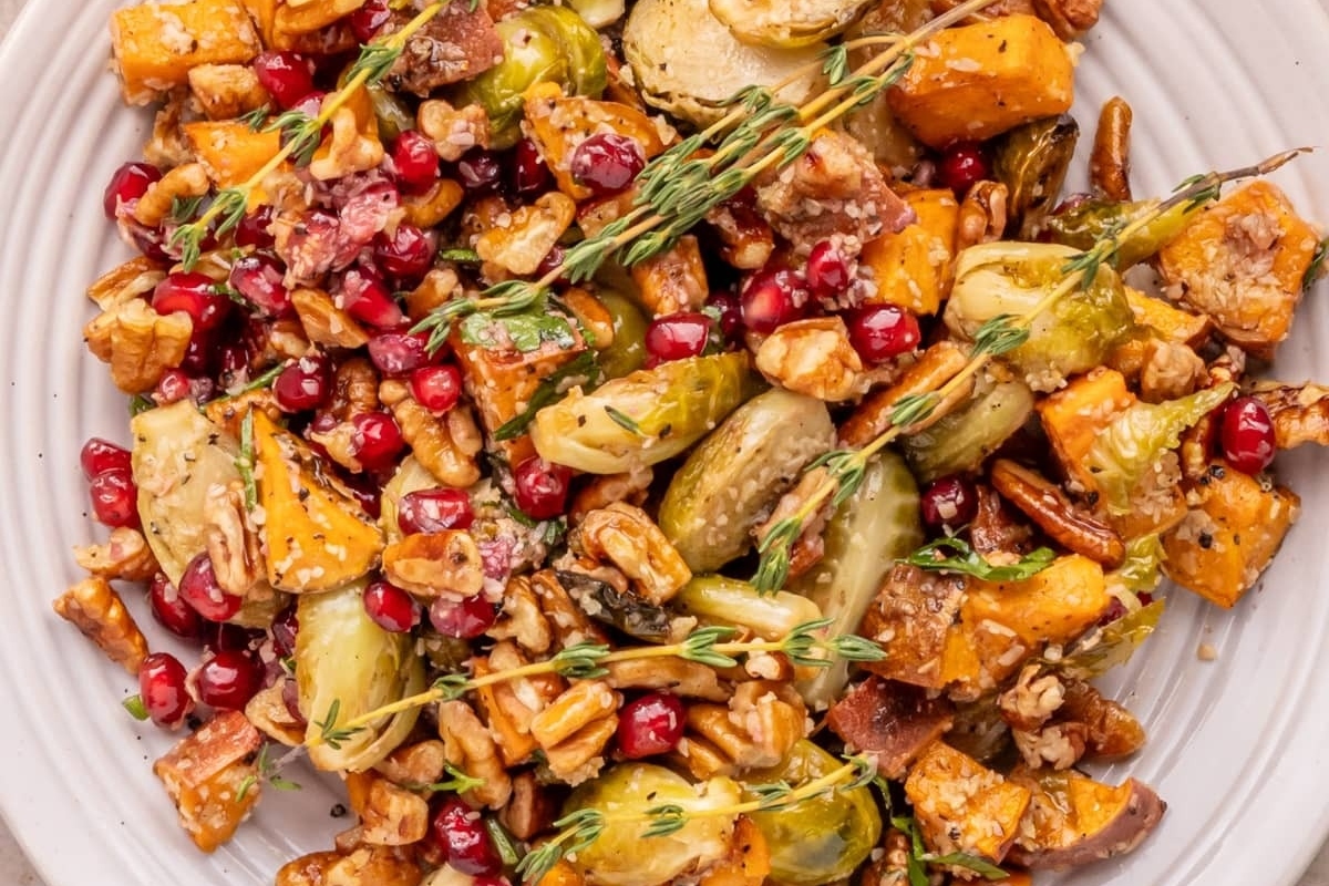 Thanksgiving-style roasted brussels sprouts with pomegranate and walnuts on a plate.