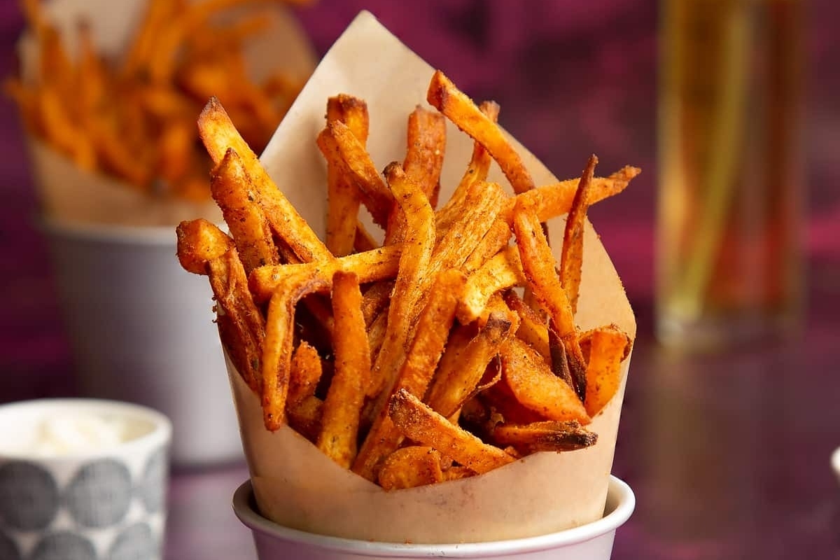 Delicious sweet potato fries served in a paper cup.