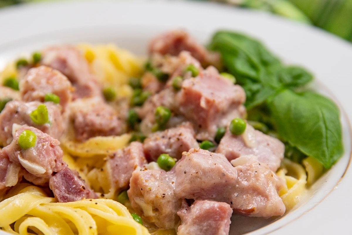 Picky Eater Recipes: Delicious pasta with ham and peas on a enticing white plate.