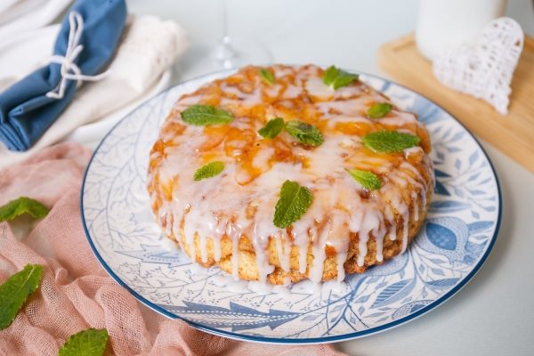 A bundt cake with icing and mint leaves on a plate.
