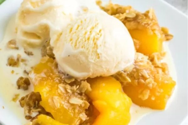 Peach crisp with ice cream and granola.