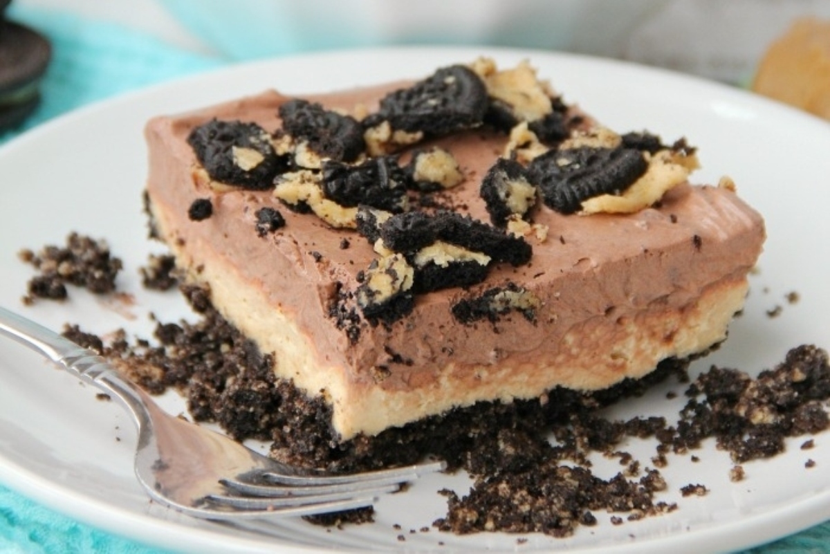 Oreo cheesecake on a plate with a festive Christmas fork.
