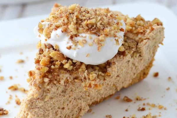 A slice of pumpkin pie with whipped cream on top.
