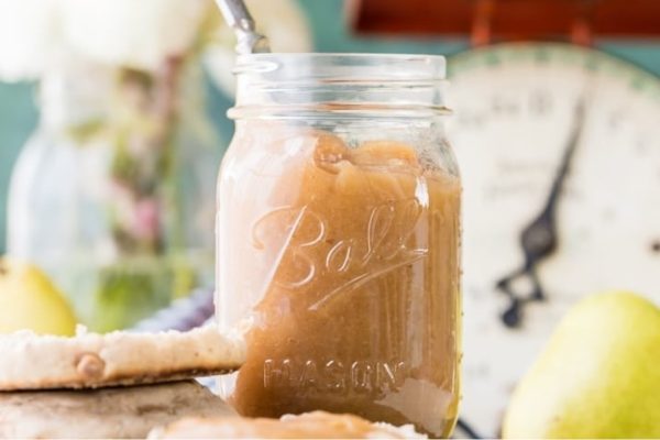 A mason jar filled with pears and a spoon.