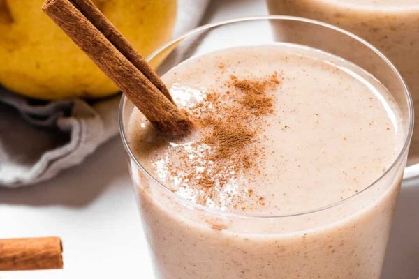 A smoothie with cinnamon and apples on a white background.