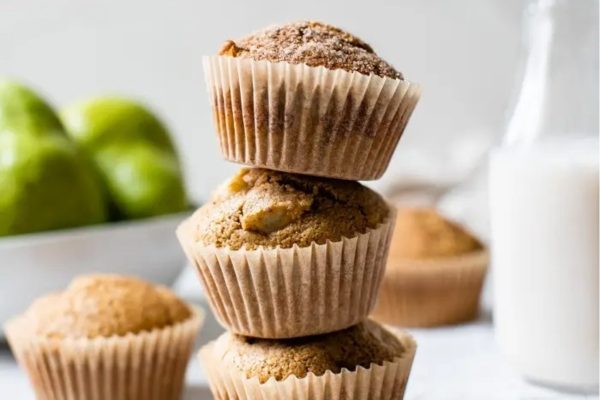 A stack of muffins with pears and a glass of milk.