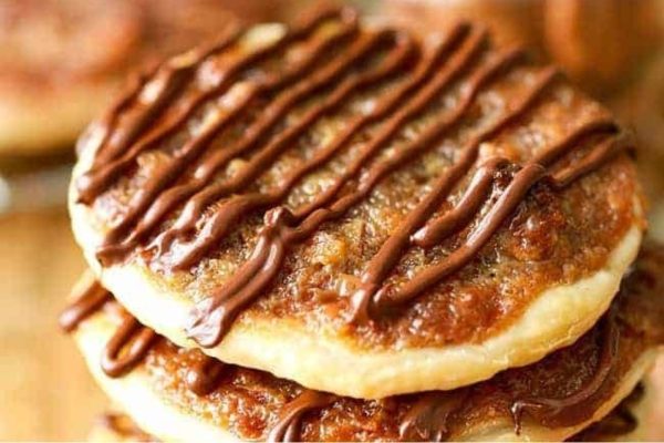 A stack of cookies with chocolate drizzle on top.