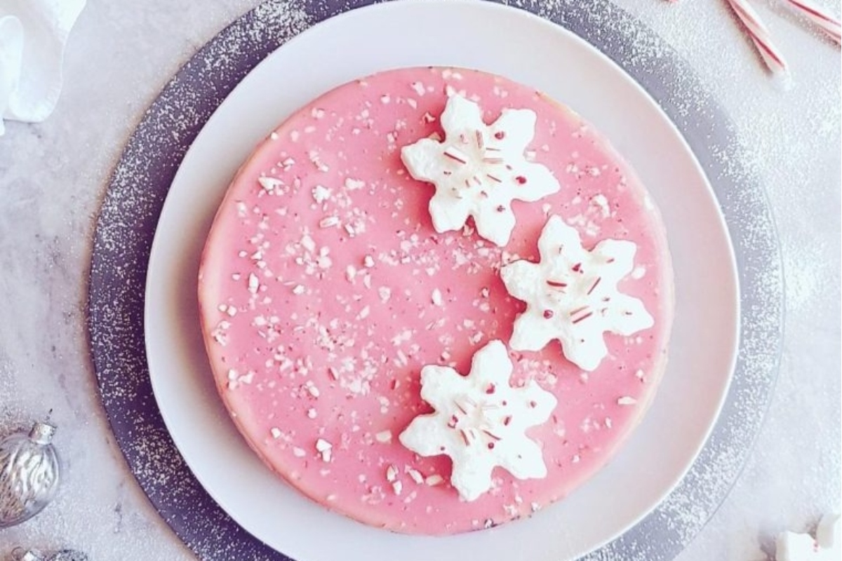 A pink cake adorned with candy canes on top, perfect for the holidays.