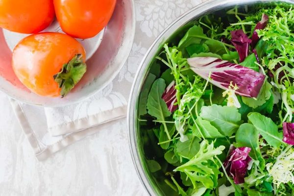 A colorful salad with greens, tomatoes, and peppers.