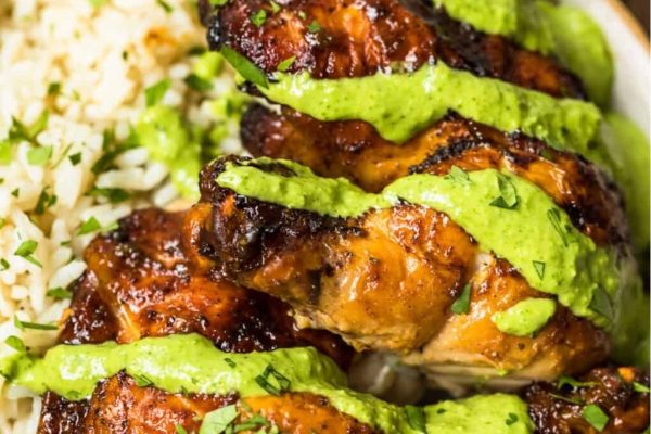 Grilled chicken with green sauce and rice in a bowl.