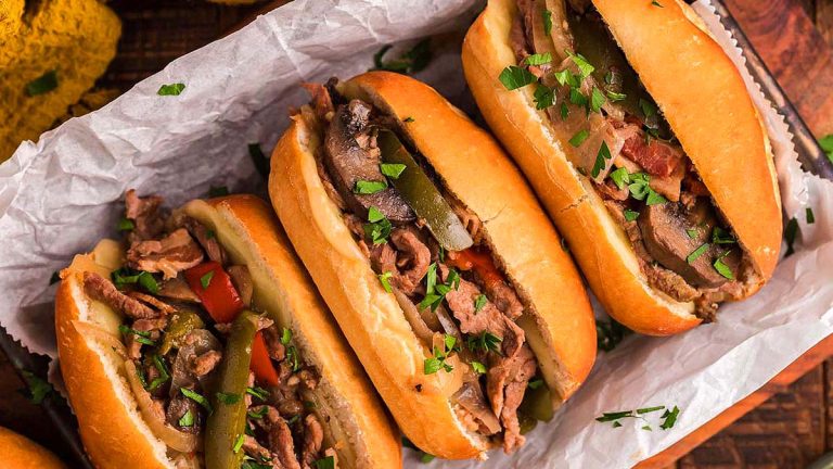 Philly cheesesteak sandwiches in a tray.