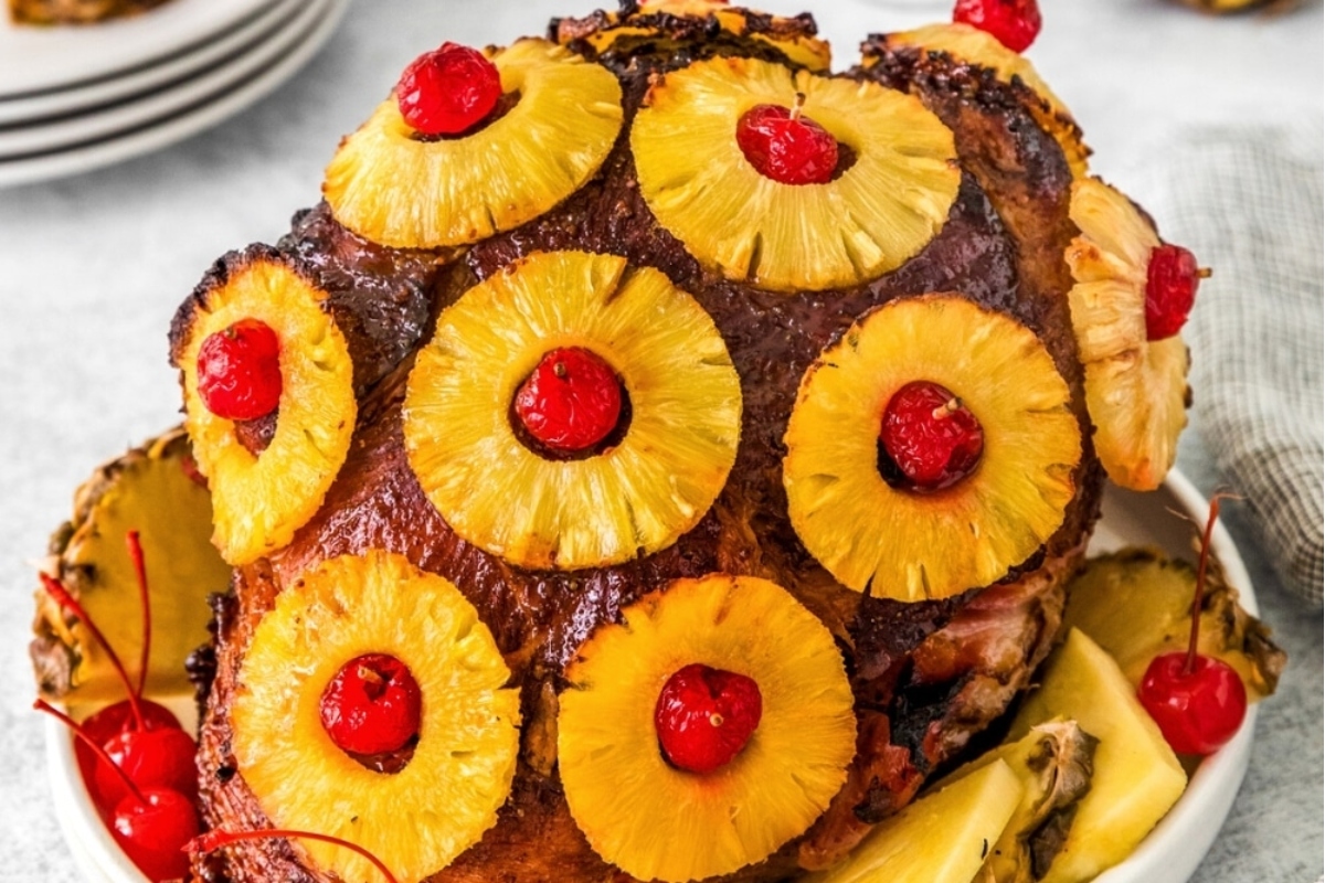 A festive Thanksgiving main featuring a succulent roasted ham adorned with luscious pineapples and cherries.