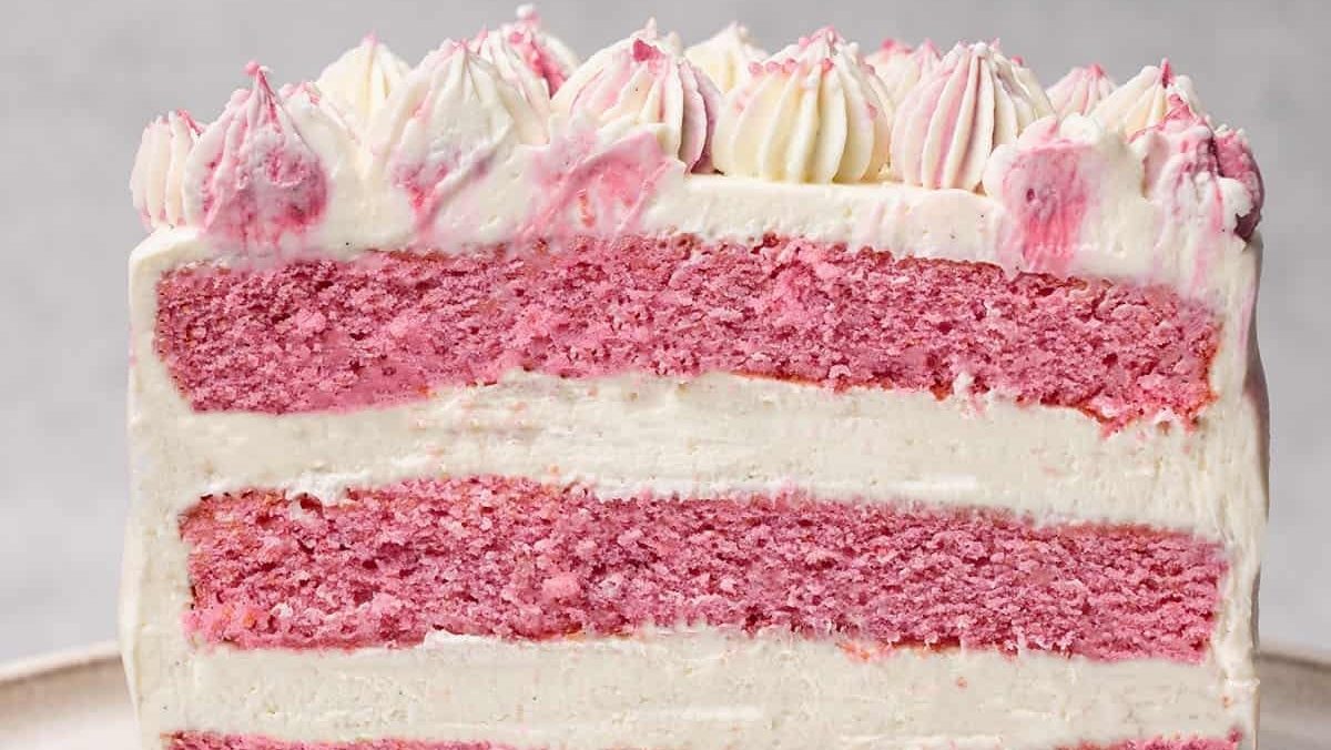 A slice of pink cake on a silver plate.