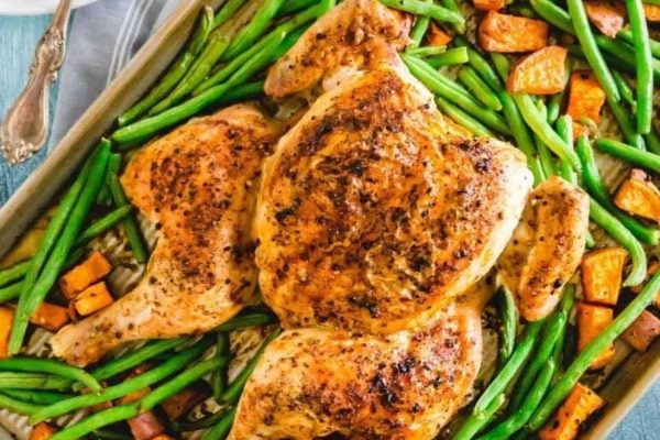 Chicken with sweet potatoes and green beans in a baking dish.