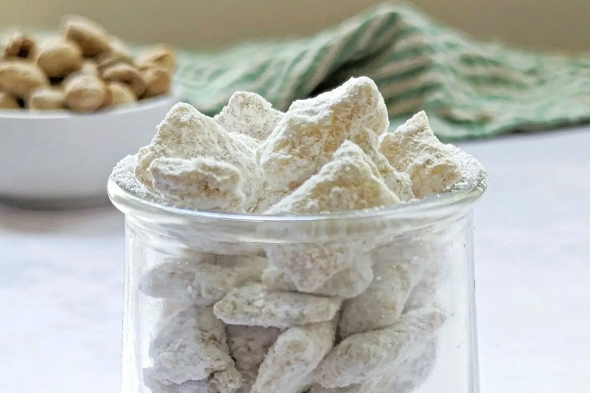 A glass jar filled with white powdered sugar for pistachio recipes.