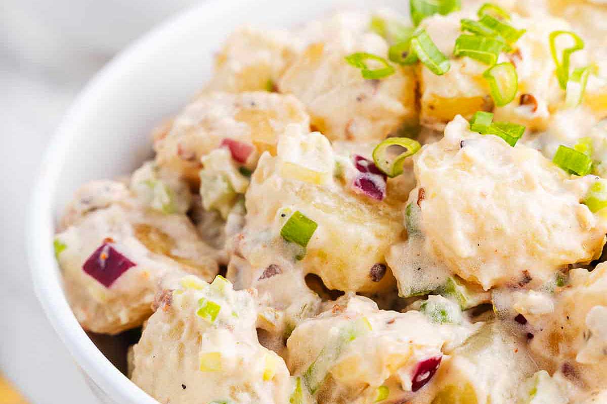 Potato salad in a white bowl.