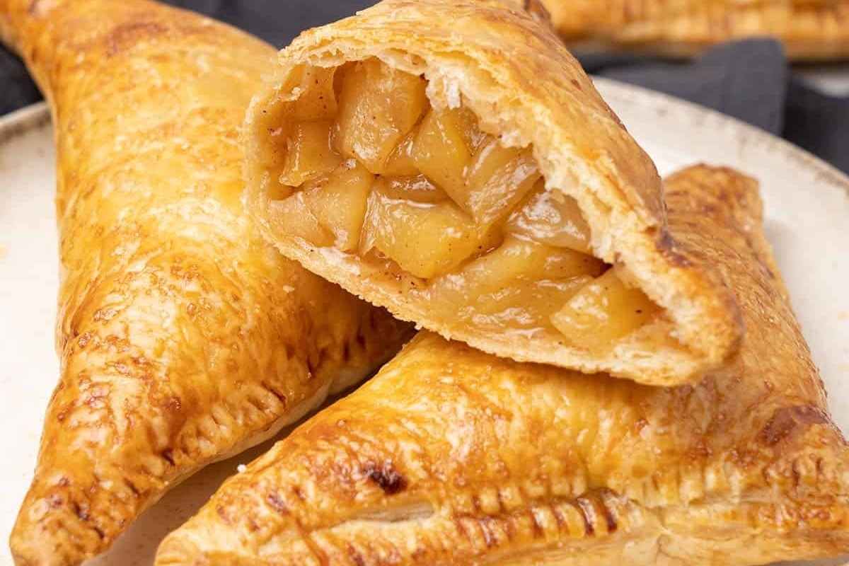 Delicious apple pies made with puff pastry recipes, showcased on a plate with a bite taken out.
