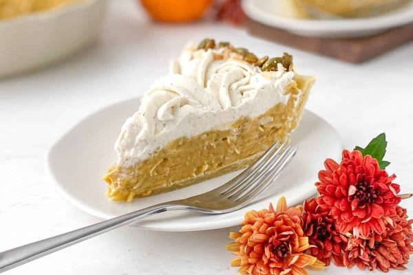 A slice of pumpkin pie on a white plate.