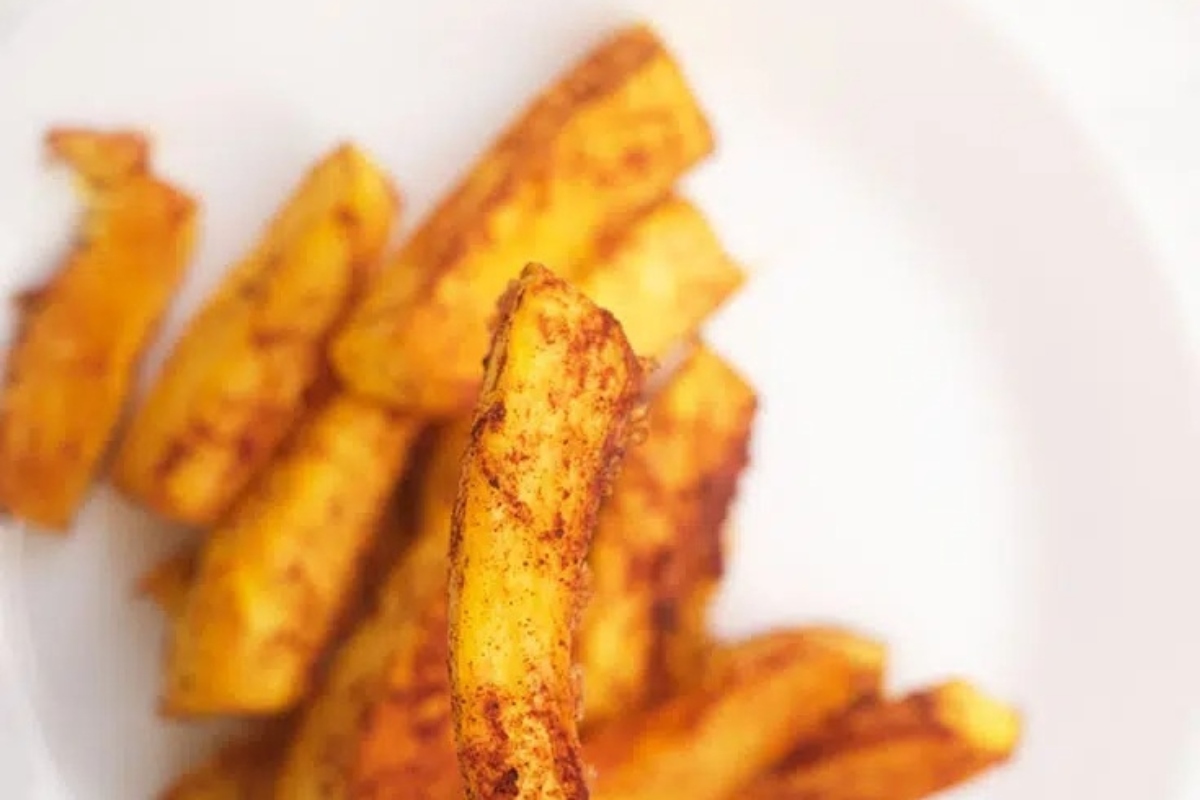 A plate of fried potato wedges on a white plate, prepared using a fry recipe.