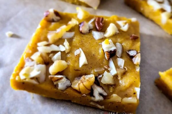 A square of pumpkin fudge with nuts on top.