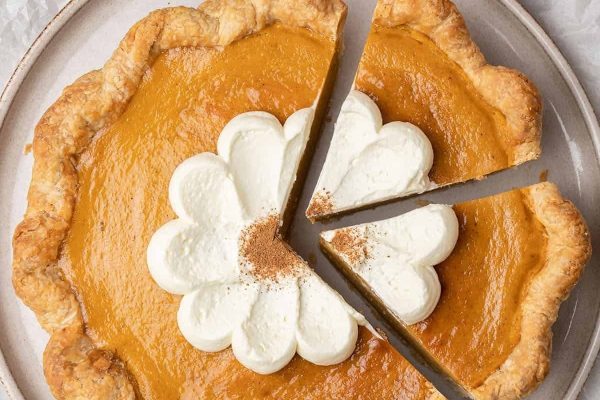 A slice of pumpkin pie with whipped cream on top.