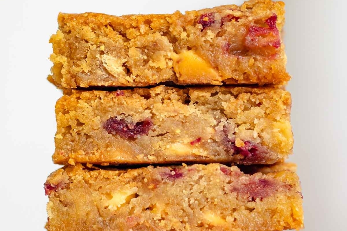 A stack of cranberry oatmeal bars stacked on top of each other, enhanced with a hint of white chocolate.