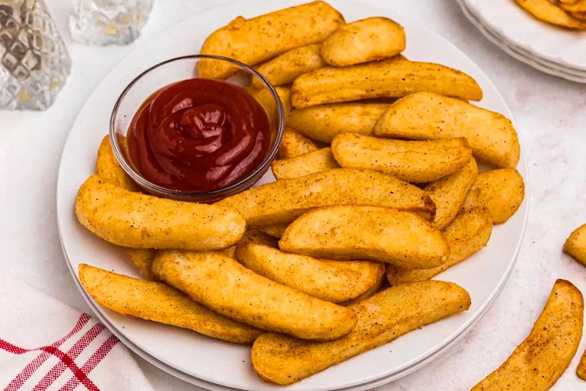 Pub food - French fries served with ketchup on a plate.