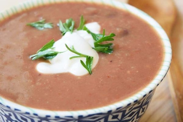 A simple black bean soup with a touch of sour cream and parsley.