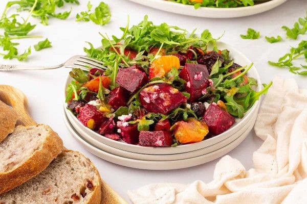 Colorful beet salad featuring a refreshing combination of arugula and oranges, ideal for Christmas gatherings.