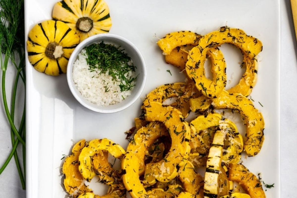 Roasted butternut squash with Italian herbs on a white plate.
