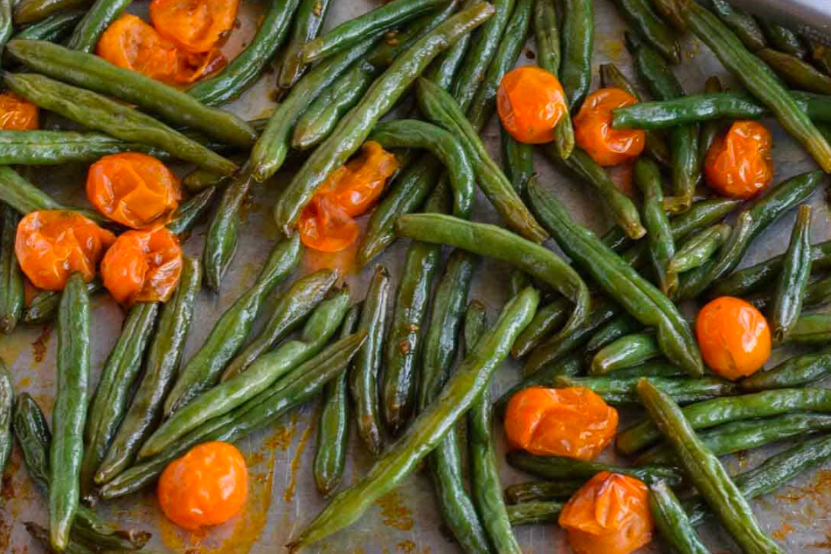Green beans and tomatoes on a baking sheet, perfect as a Thanksgiving turkey side.