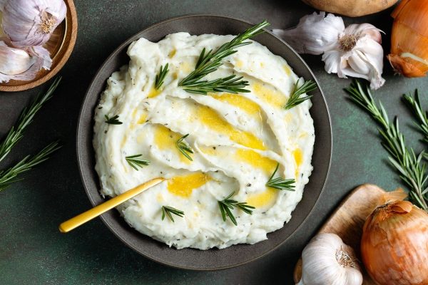 A cheap Thanksgiving Potluck Dish - a bowl of mashed potatoes with rosemary and garlic.