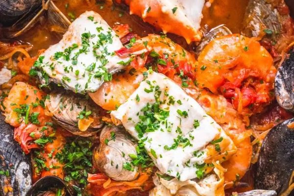 A pot of seafood stew with clams and mussels.