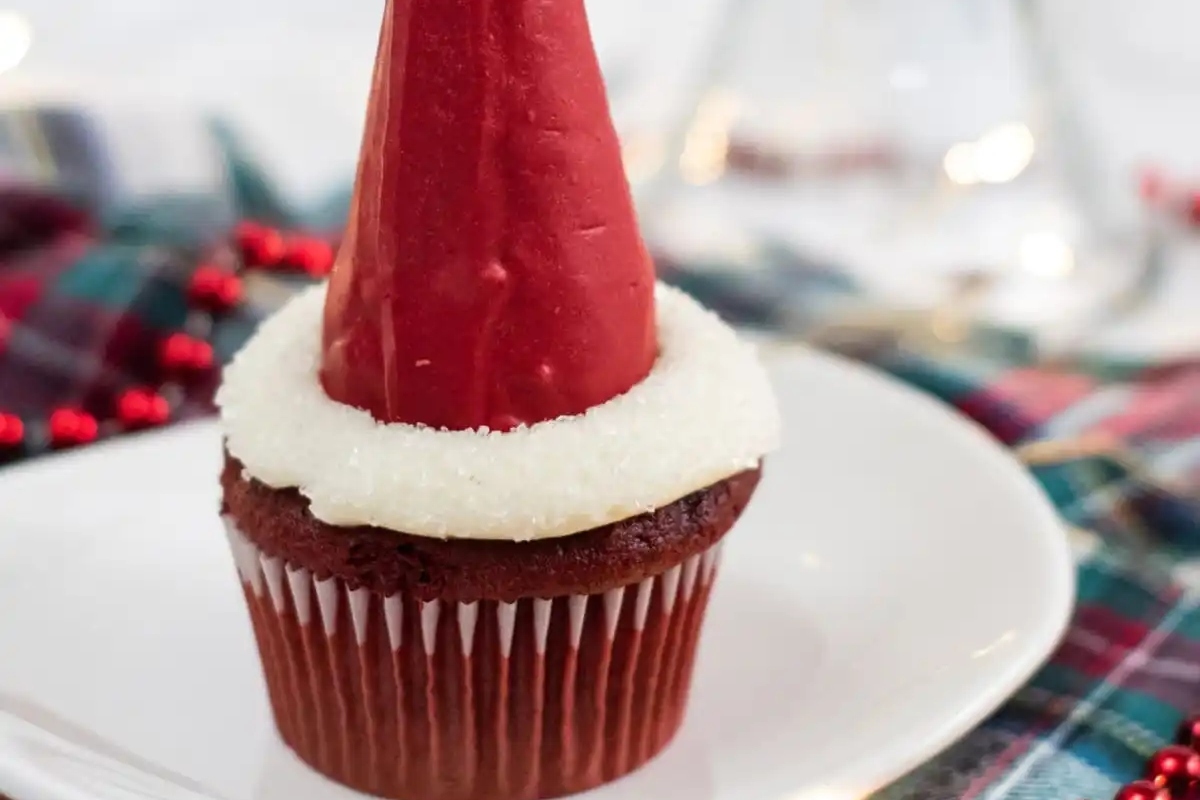 A cute cupcake with a Santa hat on top.