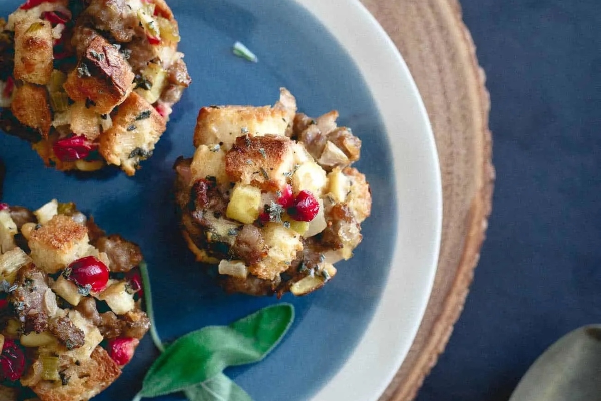 Recipe for turkey stuffing muffins with cranberries and sage, presented on a blue plate.