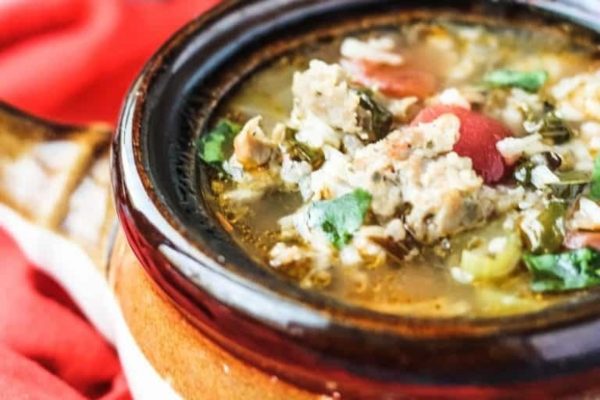 A bowl of soup with meat and vegetables in it.