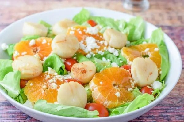 An appetizing salad recipe showcasing the vibrant flavors of oranges, tomatoes, and lettuce.