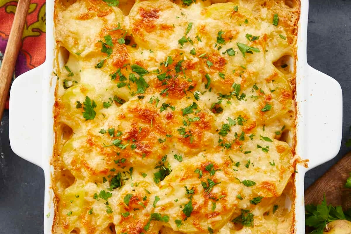 Make-ahead cheesy potato casserole in a white dish, perfect for Thanksgiving.