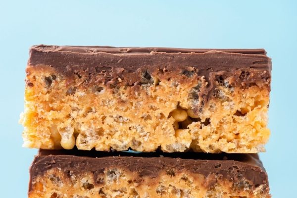 A stack of chocolate peanut butter cereal bars on a blue background.