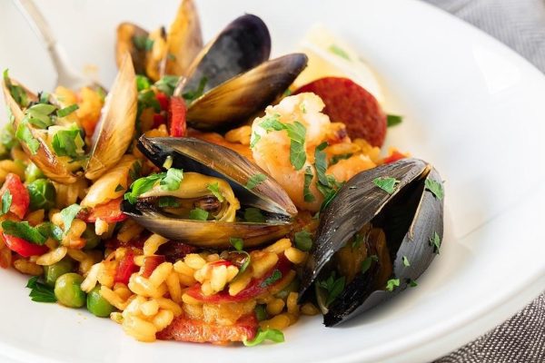 A plate of rice with seafood and clams.