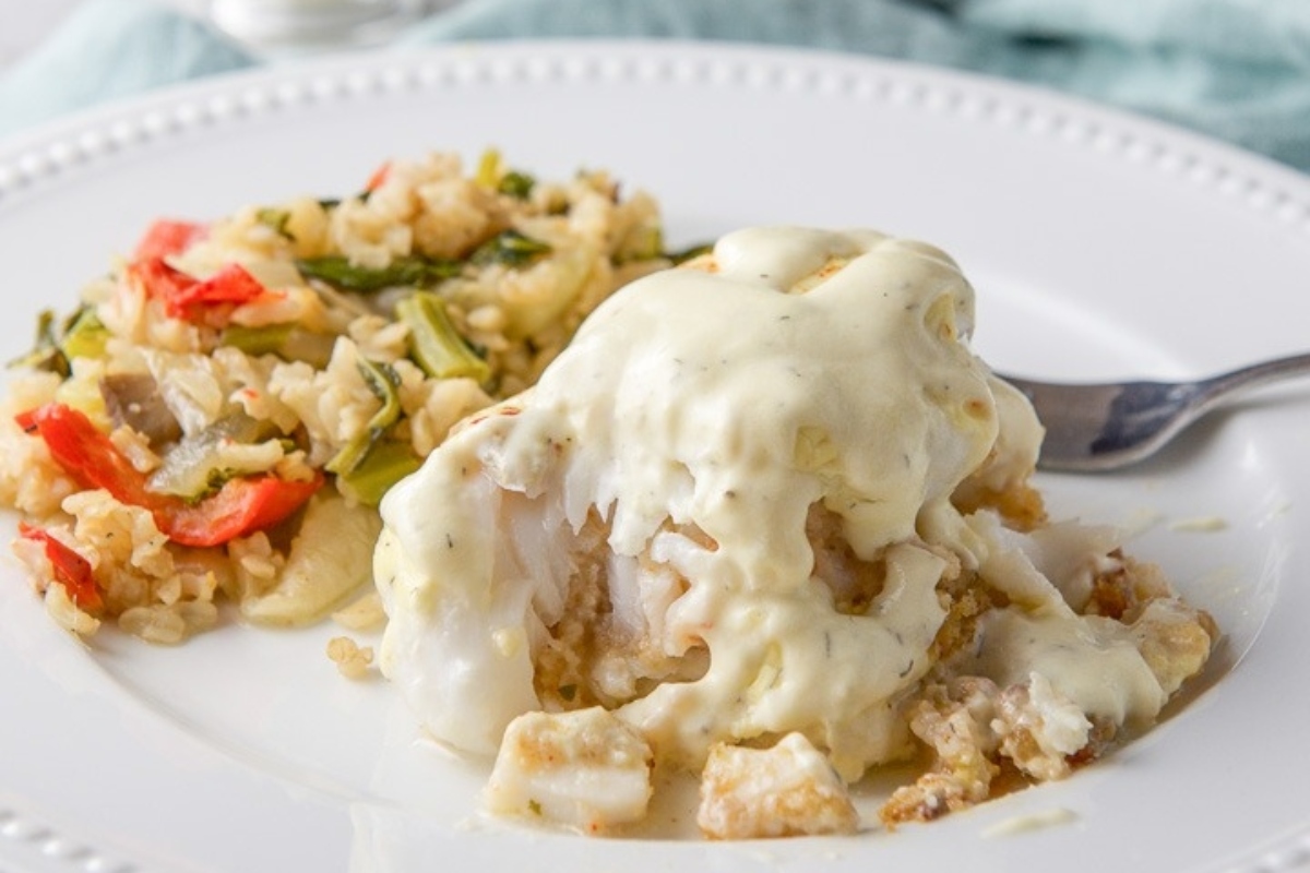 A white plate with a piece of fish and vegetables on it, perfect for a Feast.