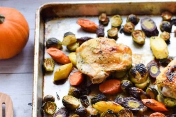 Roasted chicken and vegetables on a baking sheet.