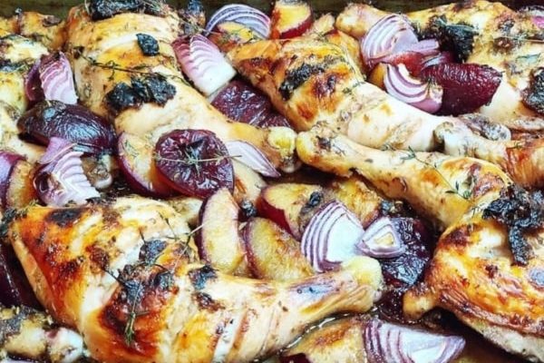 Roasted chicken with beets and onions in a pan.